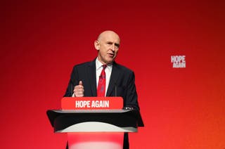 Chancellor John Healey speaking from a lectern at the Labour conference